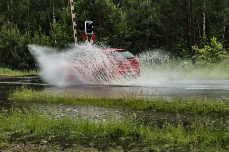 Auto fäjrt durch Pfütze